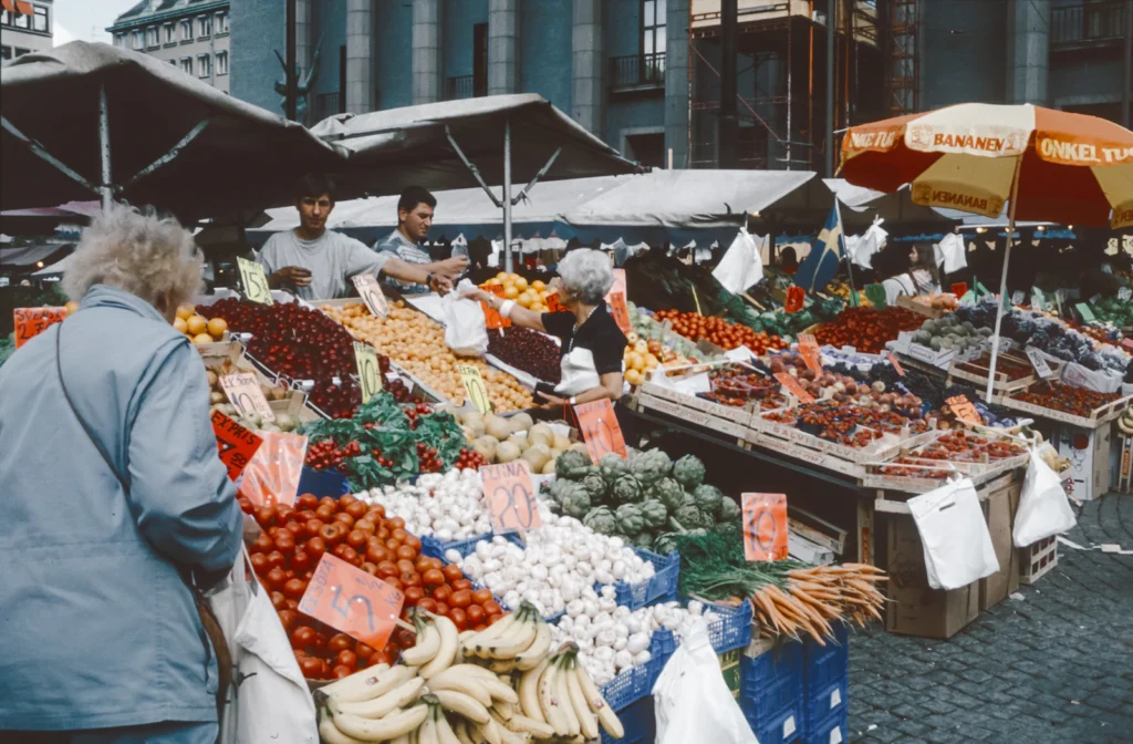 Bancas com frutas e verduras, representando alimentos baratos e redução de desperdício na Matmissionen
